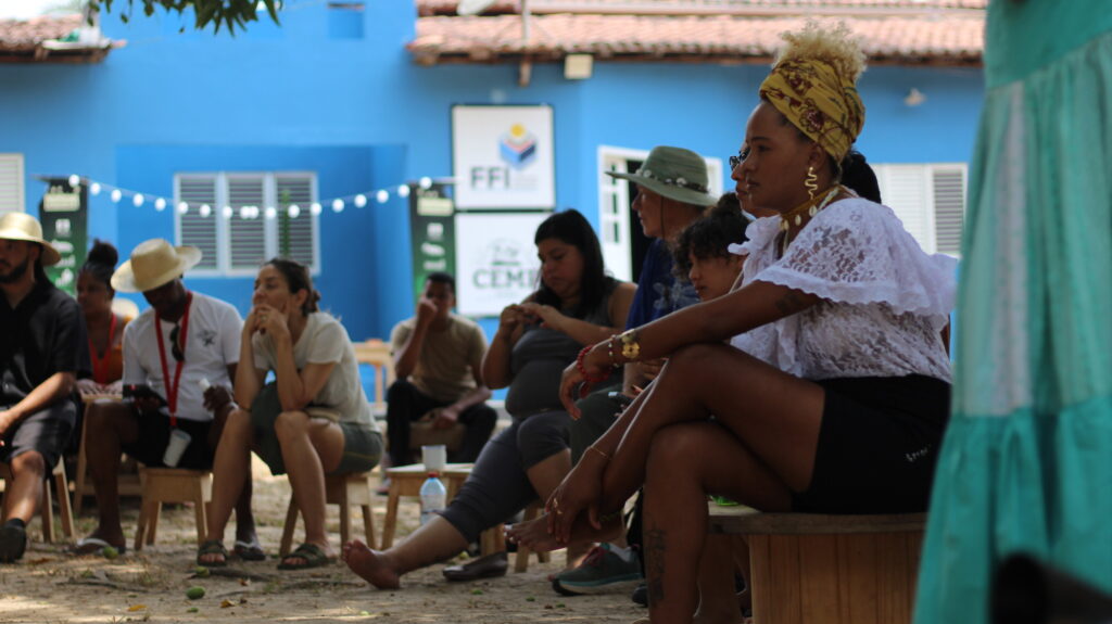 A group of fellows sit in a circle listening intently.